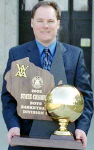 Rufus King Boy's Basketball coach Jim Gosz holding the team's second state championship trophy
